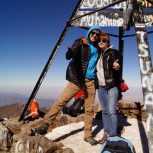 Ренат Анпилогов с женой на вершине горы, вокруг них рюкзаки и снаряжение