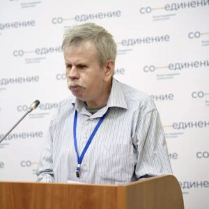 Андрей Марков на трибуне за микрофоном, позади него стенд с надписью «СоЕдинение»