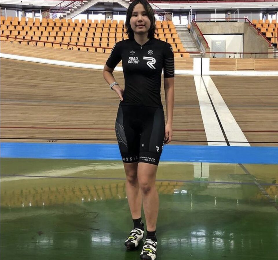 Марина Данилова в спортивной форме стоит рядом с велотреком в спорткомплексе в Крылатском