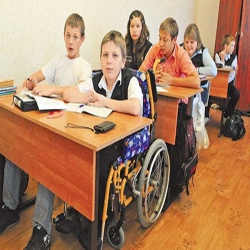 Школьный класс, рядом с обычным ребенком за партой сидит ребенок в инвалидной коляске