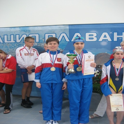 Екатерина Фаустова с группой пловцов с медалями и дипломами.