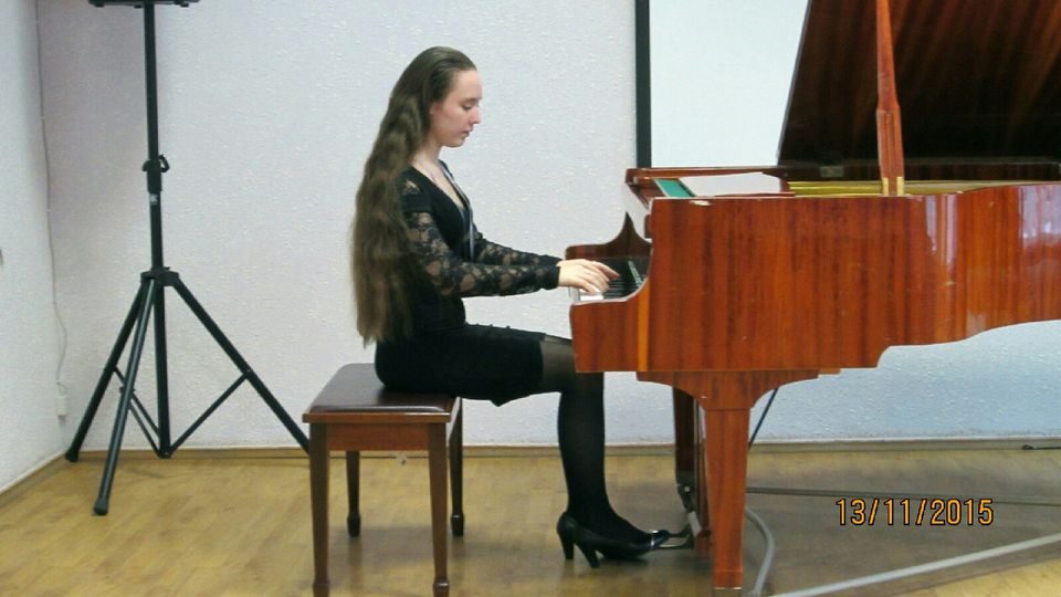 На фото Елизавета играет на рояле на концерте