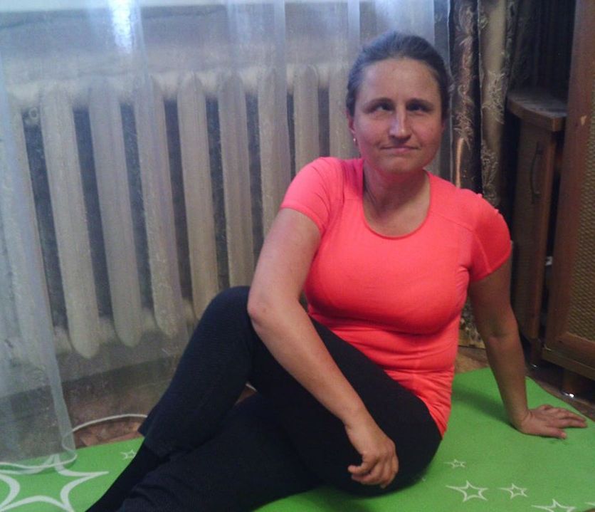 Мария сидит на коврике для занятий фитнесом