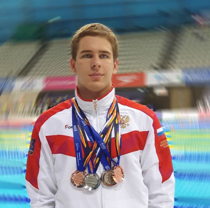 Кирилл Белоусов в спортивной форме с медалями