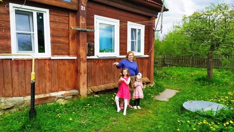 Екатерина Панкова с детьми возле дома на фоне сада и зелёной травы