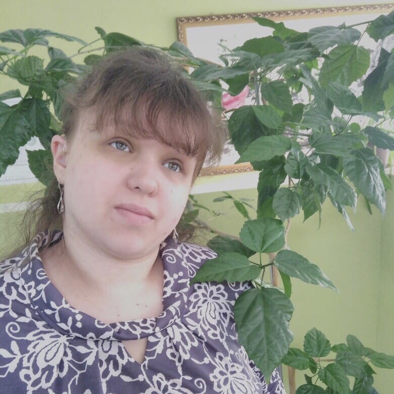 Татьяна Лебедева стоит рядом с высоким комнатным растением